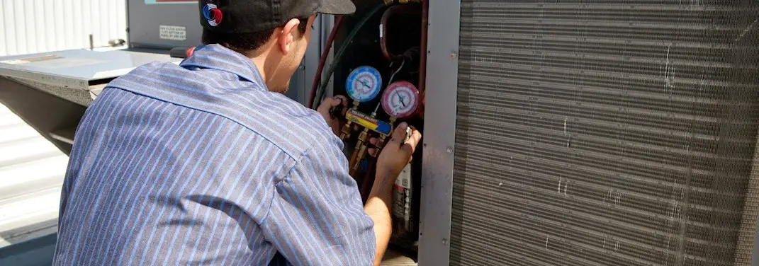 HVAC technician servicing a condenser unit in Jennings