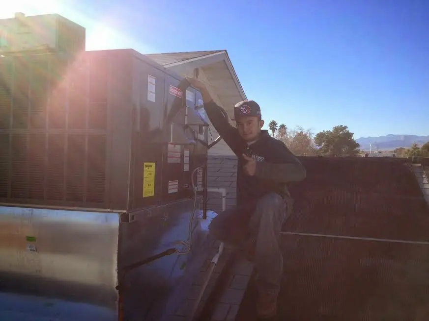 HVAC technician performing Air Duct Cleaning on a rooftop unit in Jennings